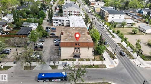 Mid-rise building featuring a flat roofline, multi-story facade with visible window openings, and an on-site parking area - 204 12404 114 Avenue, Edmonton, AB - Outdoor With View