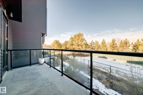 Concrete balcony with glass panel railings and black metal accents - 46 1304 Rutherford Road, Edmonton, AB - Outdoor