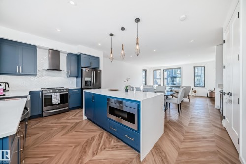 Modern kitchen featuring a large central island with an integrated microwave - 46 1304 Rutherford Road, Edmonton, AB - Indoor Photo Showing Kitchen With Stainless Steel Kitchen With Upgraded Kitchen
