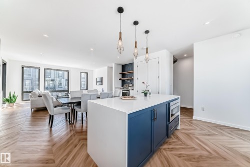 Open-concept living area featuring herringbone wood-finish flooring throughout - 46 1304 Rutherford Road, Edmonton, AB - Indoor