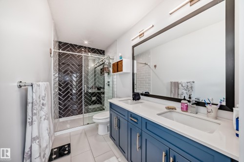 Bathroom featuring a dual vanity with a white countertop and blue cabinetry - 46 1304 Rutherford Road, Edmonton, AB - Indoor Photo Showing Bathroom