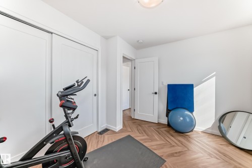 Room featuring chevron wood-finish flooring and bright white walls - 46 1304 Rutherford Road, Edmonton, AB - Indoor