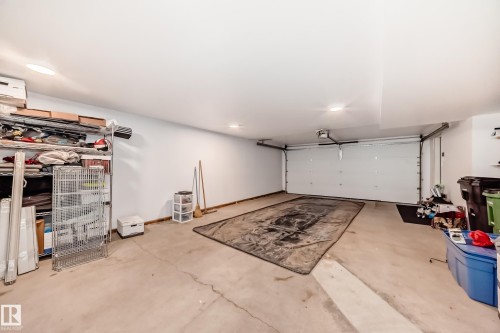 Spacious garage featuring a concrete floor, an overhead garage door, and recessed lighting - 46 1304 Rutherford Road, Edmonton, AB - Indoor Photo Showing Garage