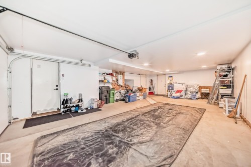 Spacious garage featuring a large automatic overhead door and a separate entry door - 46 1304 Rutherford Road, Edmonton, AB - Indoor