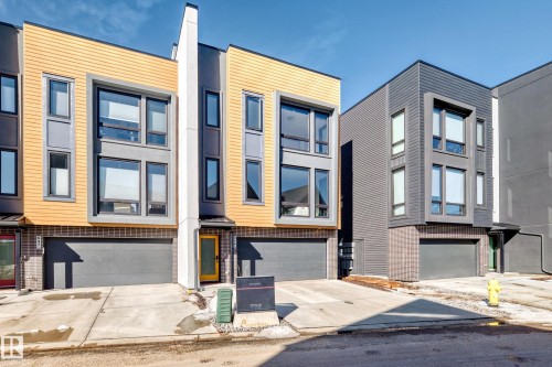 Contemporary townhouse exterior featuring a striking blend of horizontal wood-look siding and dark grey panels - 46 1304 Rutherford Road, Edmonton, AB - Outdoor With Facade