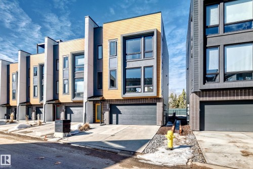 Modern townhome exterior with mixed material facade featuring vertical siding, large format windows, and a private garage - 46 1304 Rutherford Road, Edmonton, AB - Outdoor With Facade