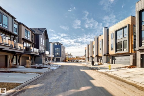 Modern townhome exteriors featuring multi-toned siding, expansive windows, glass-paneled balconies, and integrated garages - 46 1304 Rutherford Road, Edmonton, AB - Outdoor With Facade