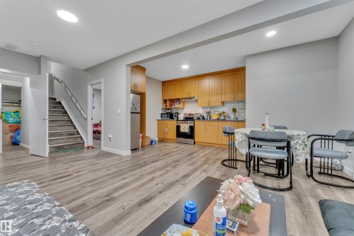 Open-concept living area featuring wood-finish flooring, recessed lighting, and a neutral wall palette - 1809 18A Avenue, Edmonton, AB 