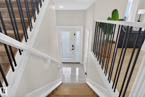 Foyer featuring a white entry door with frosted glass panels and sidelights, polished tile flooring, and a recessed ceiling light - 4204 55Av, Lamont, AB 