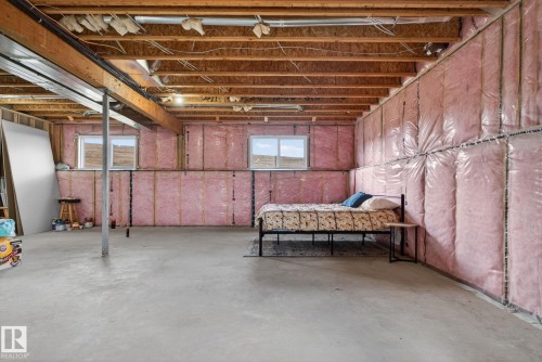 Unfinished basement space featuring exposed wood joists and subfloor, concrete flooring, and insulated walls - 4204 55Av, Lamont, AB 