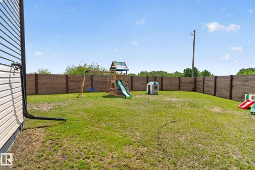 Expansive backyard featuring a full perimeter privacy fence and a verdant lawn - 4204 55Av, Lamont, AB 