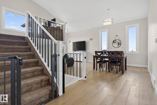 Staircase featuring dark carpeted steps and a white railing with black balusters - 4204 55Av, Lamont, AB 