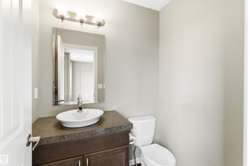 Bathroom vanity with a vessel sink and a wall-mounted light fixture - 8204 180 Avenue, Edmonton, AB 
