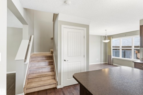 Staircase featuring carpeted treads and white wood railings - 8204 180 Avenue, Edmonton, AB 