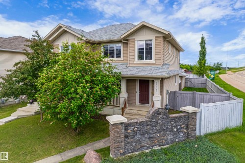 Two-story residence featuring light tan siding and a dark shingle roof - 8204 180 Avenue, Edmonton, AB 