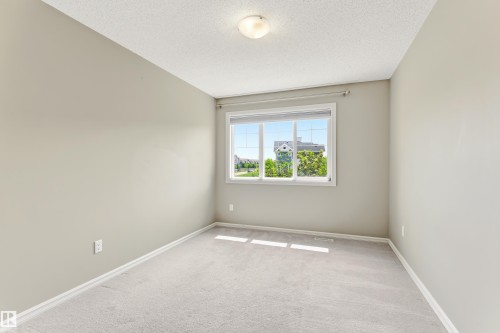 Room with light grey carpeting, painted walls, and a white trim baseboard - 8204 180 Avenue, Edmonton, AB 