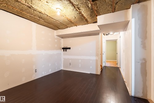 Interior space featuring dark wood-finish flooring and unpainted drywall - 8204 180 Avenue, Edmonton, AB 
