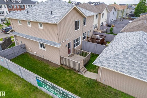 Rear exterior of a two-story residence featuring light beige siding and a multi-toned gray shingle roof - 8204 180 Avenue, Edmonton, AB 