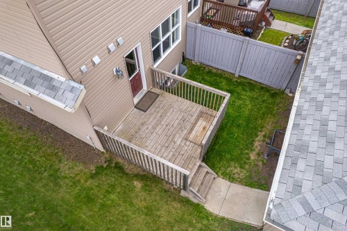 Expansive wood deck with railing and steps leading to a concrete pathway - 8204 180 Avenue, Edmonton, AB 