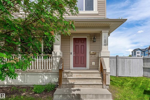 Front entry featuring a four-panel door, concrete steps, and a sheltered porch - 8204 180 Avenue, Edmonton, AB 
