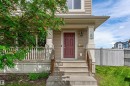 Front entry featuring a four-panel door, concrete steps, and a sheltered porch - 8204 180 Avenue, Edmonton, AB 
