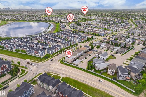 Expansive residential development featuring a large central lake, diverse housing architecture including townhomes and detached homes, and established roadways - 8204 180 Avenue, Edmonton, AB 