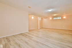 Spacious room featuring wood-finish flooring, neutral-toned walls, recessed lighting, and multiple electrical outlets - 