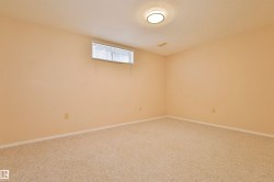 Room featuring neutral carpet flooring, light-colored walls, and a single ceiling-mounted light fixture - 