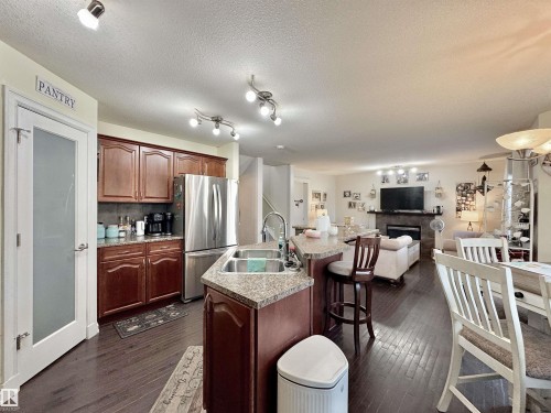 Open-concept living space featuring wood-finish flooring throughout - 105 Greystone Crescent, Spruce Grove, AB 