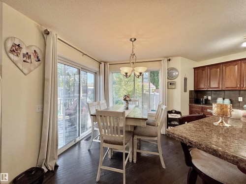 Dining area with wood-finish flooring and a central chandelier - 105 Greystone Crescent, Spruce Grove, AB 