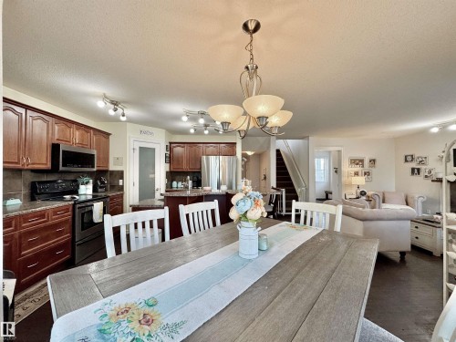 Open-concept living space with dark wood-finish flooring - 105 Greystone Crescent, Spruce Grove, AB 