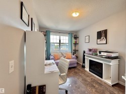 Interior room featuring wood-finish flooring, a double window with blinds, and light-toned walls - 