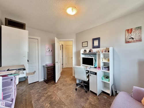 Interior room featuring neutral wall paint, a built-in desk with shelving, and wood-finish flooring - 105 Greystone Crescent, Spruce Grove, AB 