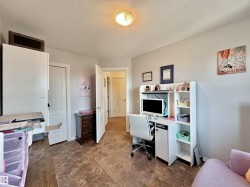 Interior room featuring neutral wall paint, a built-in desk with shelving, and wood-finish flooring - 