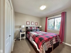 Bedroom featuring neutral wall paint, a window with blinds, and carpeted flooring - 
