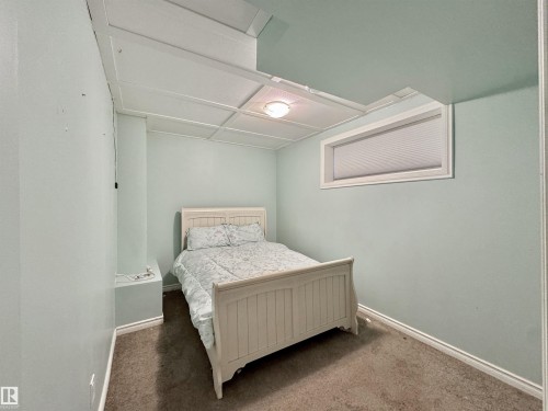 Interior room featuring a drop ceiling with recessed lighting, a horizontal window with blinds, light blue painted walls, and brown carpeting - 105 Greystone Crescent, Spruce Grove, AB 