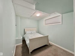 Interior room featuring a drop ceiling with recessed lighting, a horizontal window with blinds, light blue painted walls, and brown carpeting - 