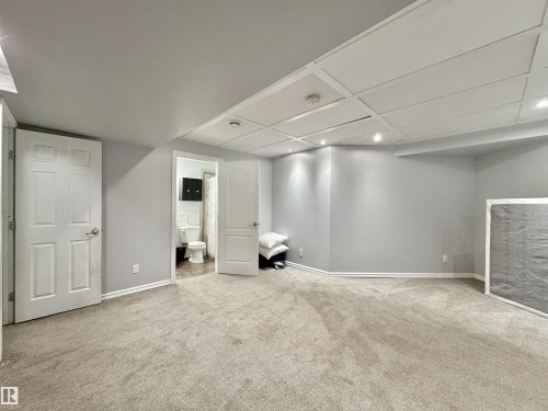 Spacious room featuring light gray walls, neutral carpeting, and recessed lighting - 105 Greystone Crescent, Spruce Grove, AB 