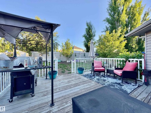 Expansive outdoor deck featuring white railing and mature perimeter foliage - 105 Greystone Crescent, Spruce Grove, AB 