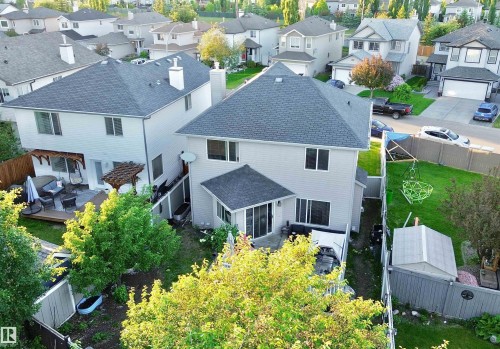 Rear exterior featuring light-toned siding, a multi-level roofline, and multiple windows - 105 Greystone Crescent, Spruce Grove, AB 