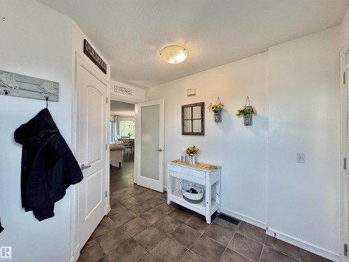 Entryway featuring tile flooring, a frosted glass interior door, and a flush-mount ceiling light fixture - 105 Greystone Crescent, Spruce Grove, AB 