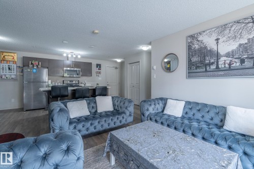 Open-concept living area with wood-finish flooring - 107 142 Ebbers Boulevard, Edmonton, AB 