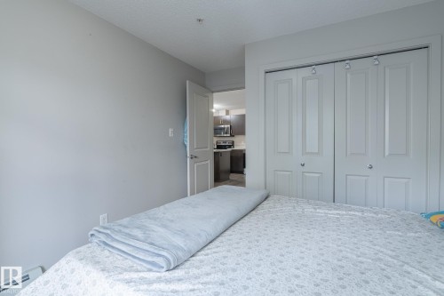 Interior room featuring a textured ceiling and light gray walls - 107 142 Ebbers Boulevard, Edmonton, AB 