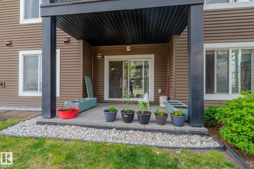 Ground-level patio featuring concrete pavers, a gravel border, and direct access to interior spaces via a sliding glass door - 107 142 Ebbers Boulevard, Edmonton, AB 
