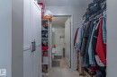 Integrated closet system featuring white cabinetry, open shelving, and a hanging clothes rod - 107 142 Ebbers Boulevard, Edmonton, AB 
