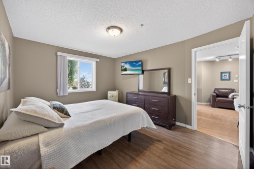 Interior room featuring wood-finish flooring, a white window frame, and neutral wall paint - 111 3425 19, Edmonton, AB 