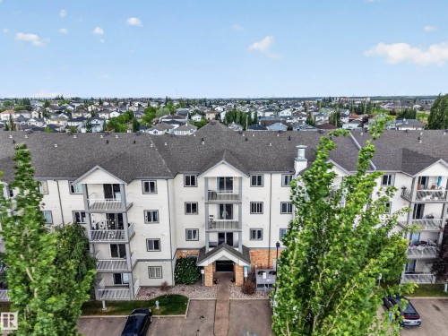 Multi-story residential building with light-colored siding and dark shingle roofing - 111 3425 19, Edmonton, AB 