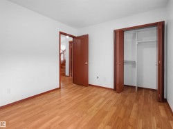 Wood-finish flooring throughout, bright white walls, and dark wood trim - 