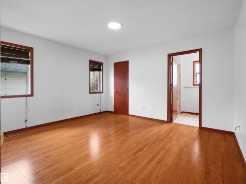 Spacious room featuring wood-finish flooring and white walls - 2832 36B Avenue, Edmonton, AB - Indoor Photo Showing Other Room