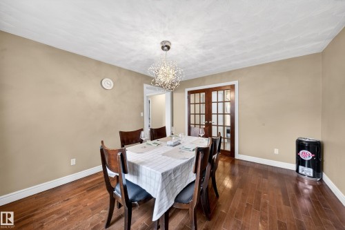 Dining area featuring wood-finish flooring, neutral wall tones, and white trim - 34 Grand Meadow Crescent, Edmonton, AB 